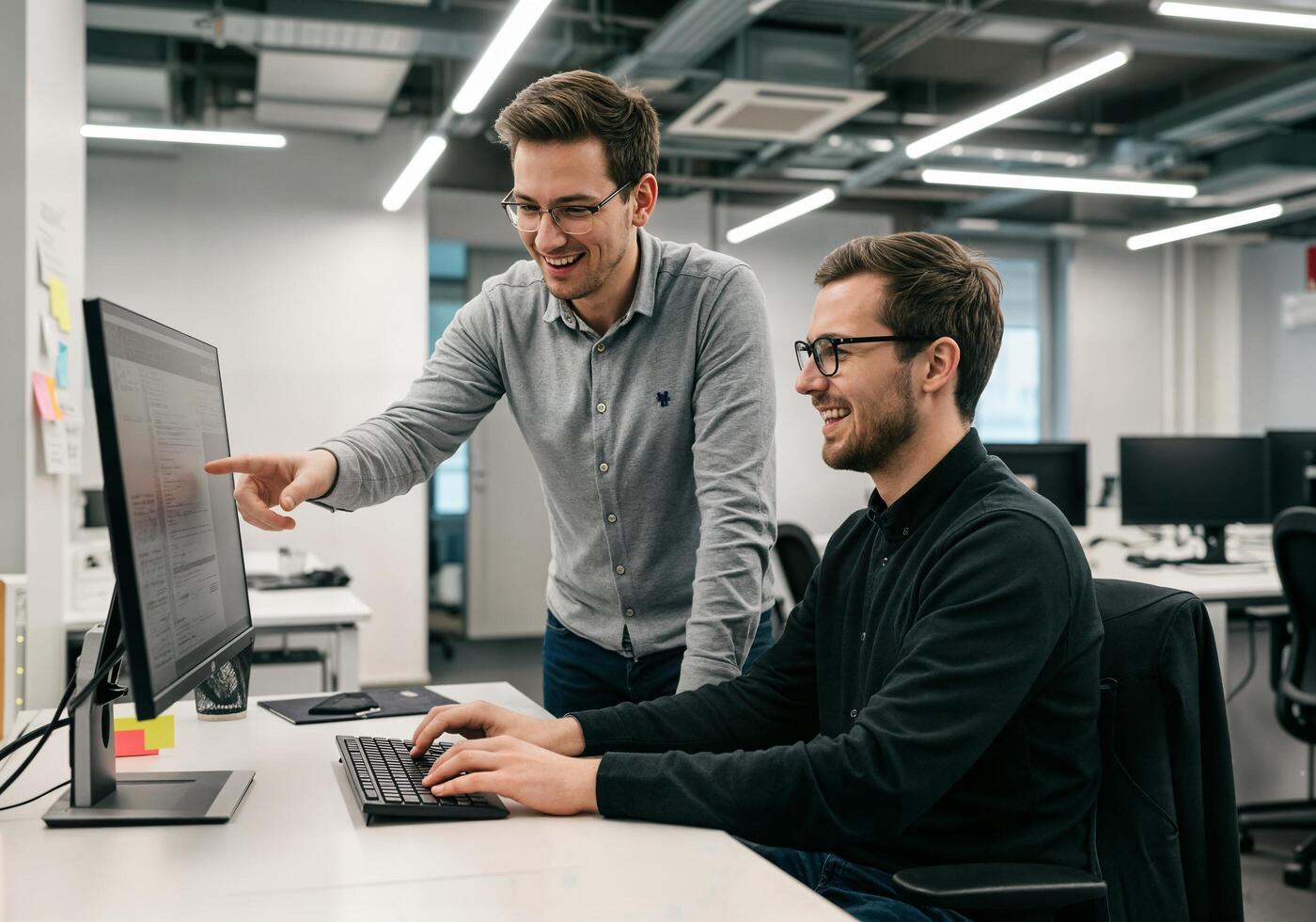 Two men working on a computer in an office photo