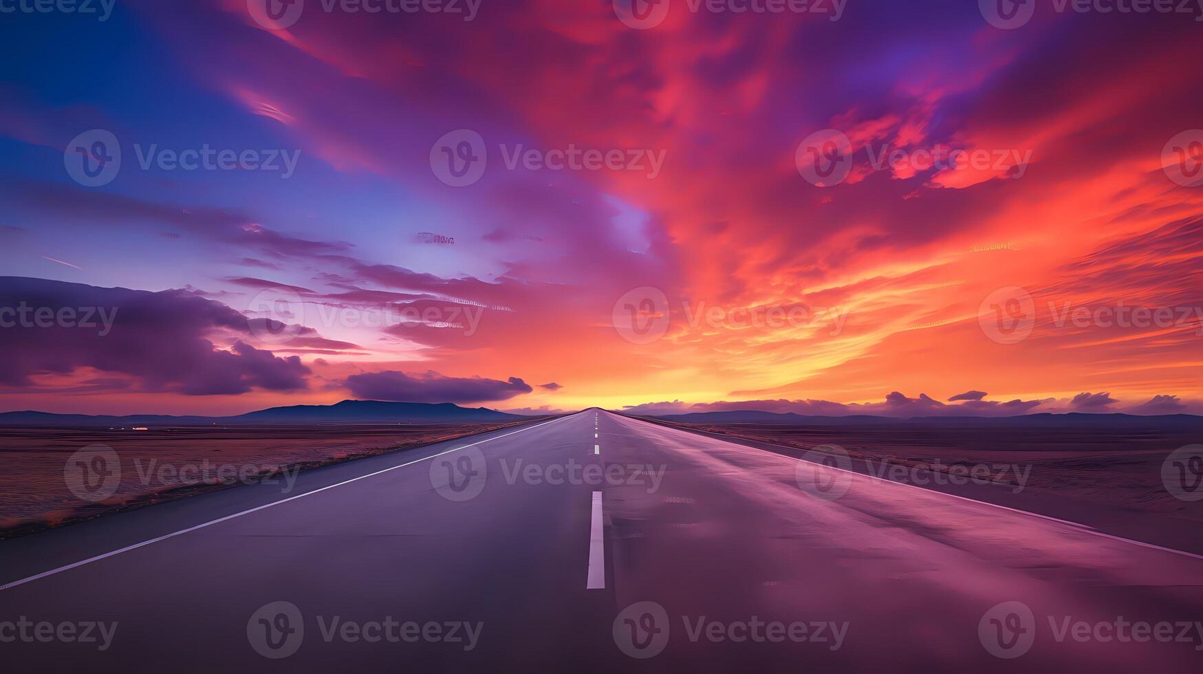 A long and winding road with a beautiful sunset in the backgroun photo
