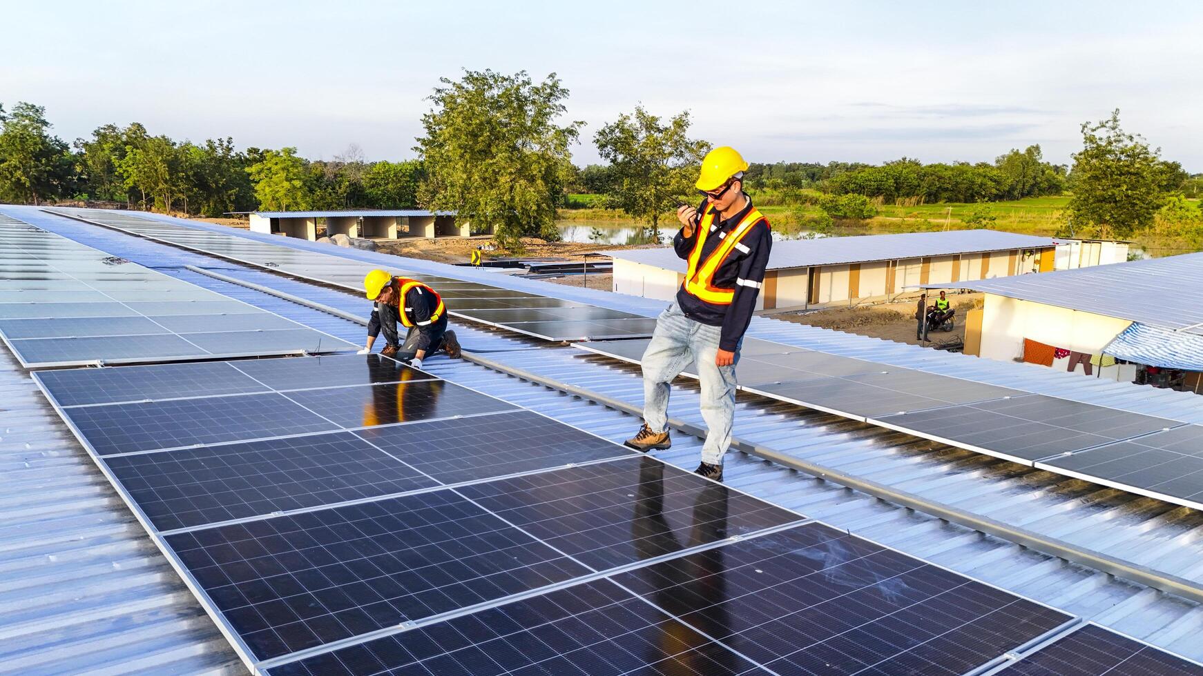 workers in safety gear installing solar panels on a rooftop, highlighting renewable energy, sustainability, and the integration of skilled labor in setting up efficient solar power systems. photo