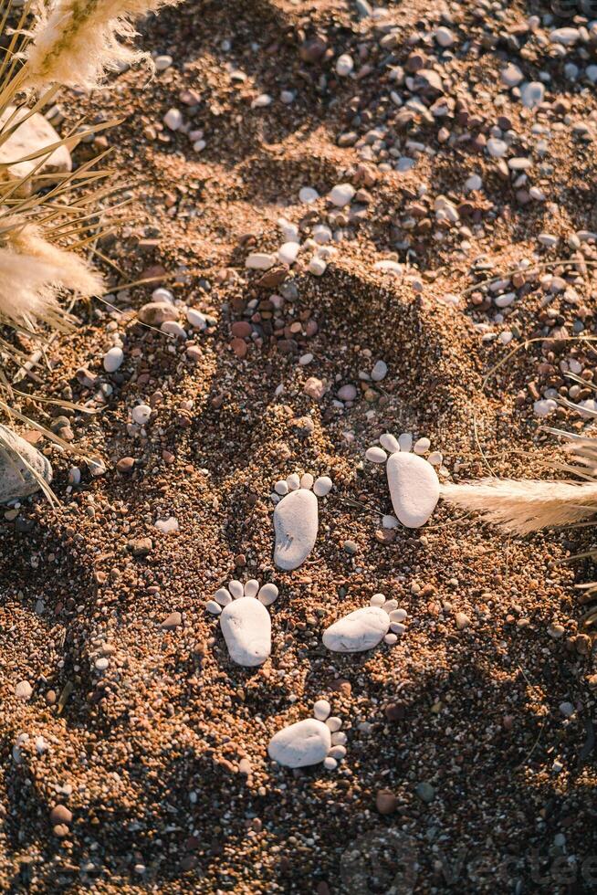 Footprints in the sand made of pebbles in sunlight photo