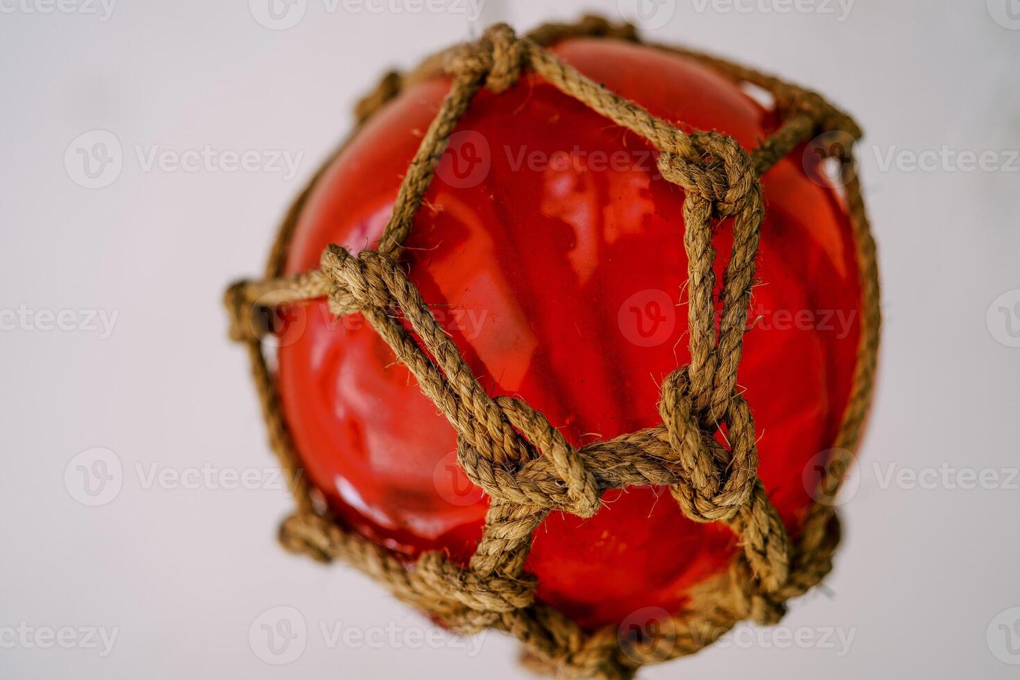 Red fishing glass float in the net on a light background photo