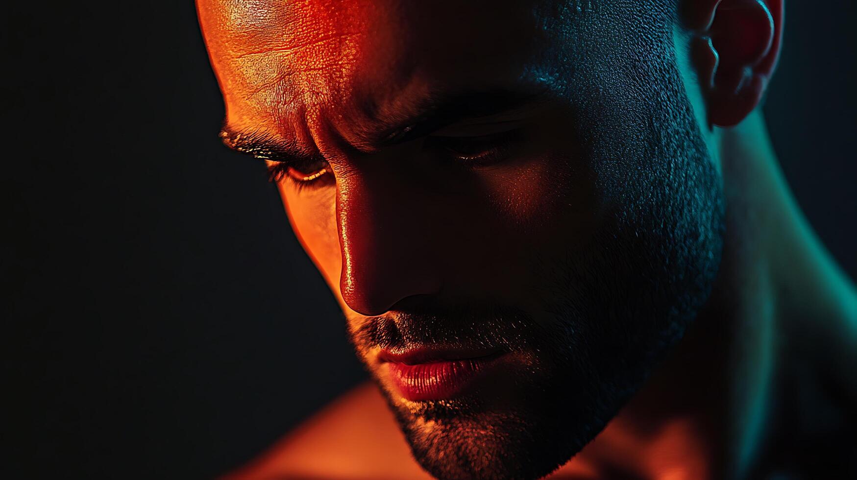 Intense portrait of a man with short hair and a beard dramatically lit with red and teal gels in a dark setting photo