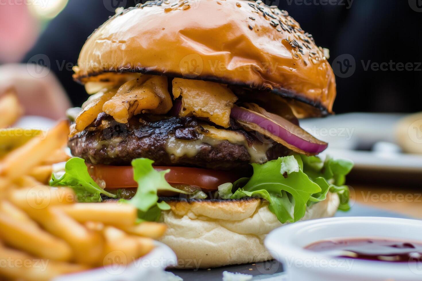 A close-up shot showcases a mouthwatering hamburger served with crispy fries and berry dipping sauce. photo