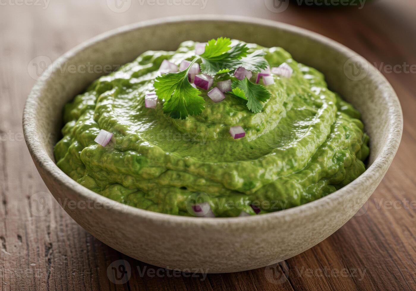 Close-up shot of a bowl filled with creamy fresh guacamole dip, garnished with red onion and cilantro. photo