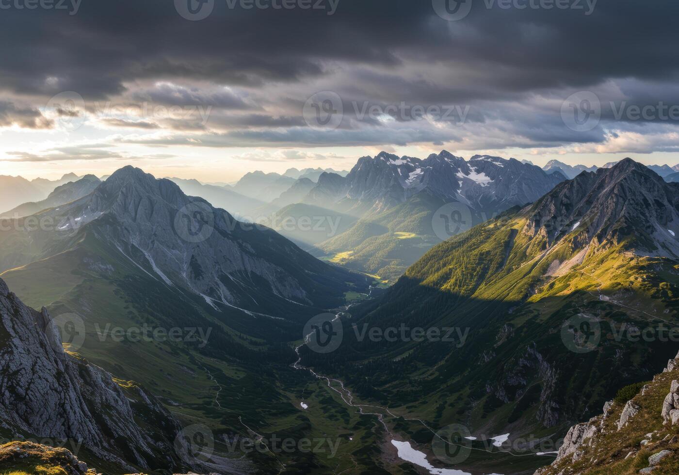 A mesmerizing view of the Alps mountain range with sunlight piercing through the clouds. photo