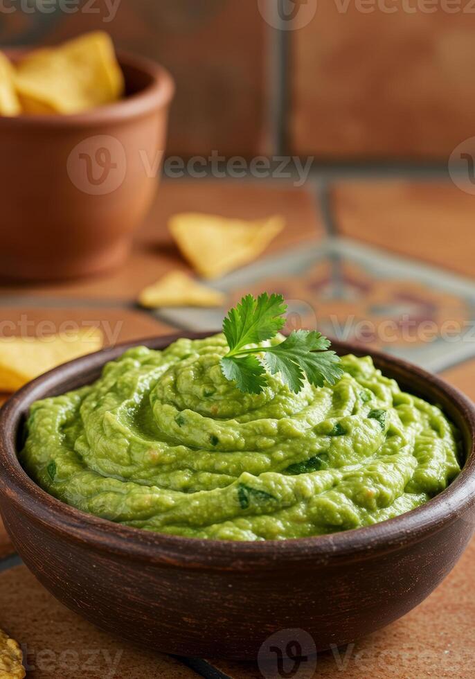 Freshly made guacamole served in a rustic wooden bowl, topped with cilantro and accompanied by tortilla chips. photo