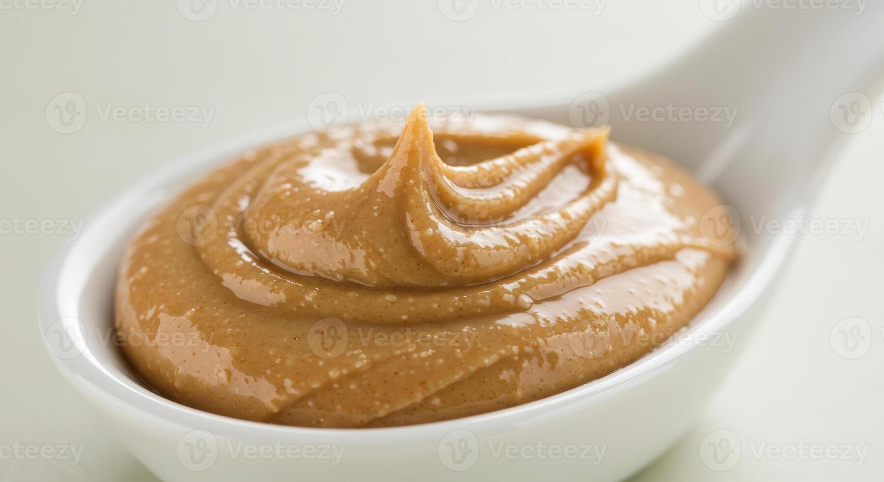 A spoonful of smooth and creamy peanut butter, ready to be enjoyed as a tasty treat photo