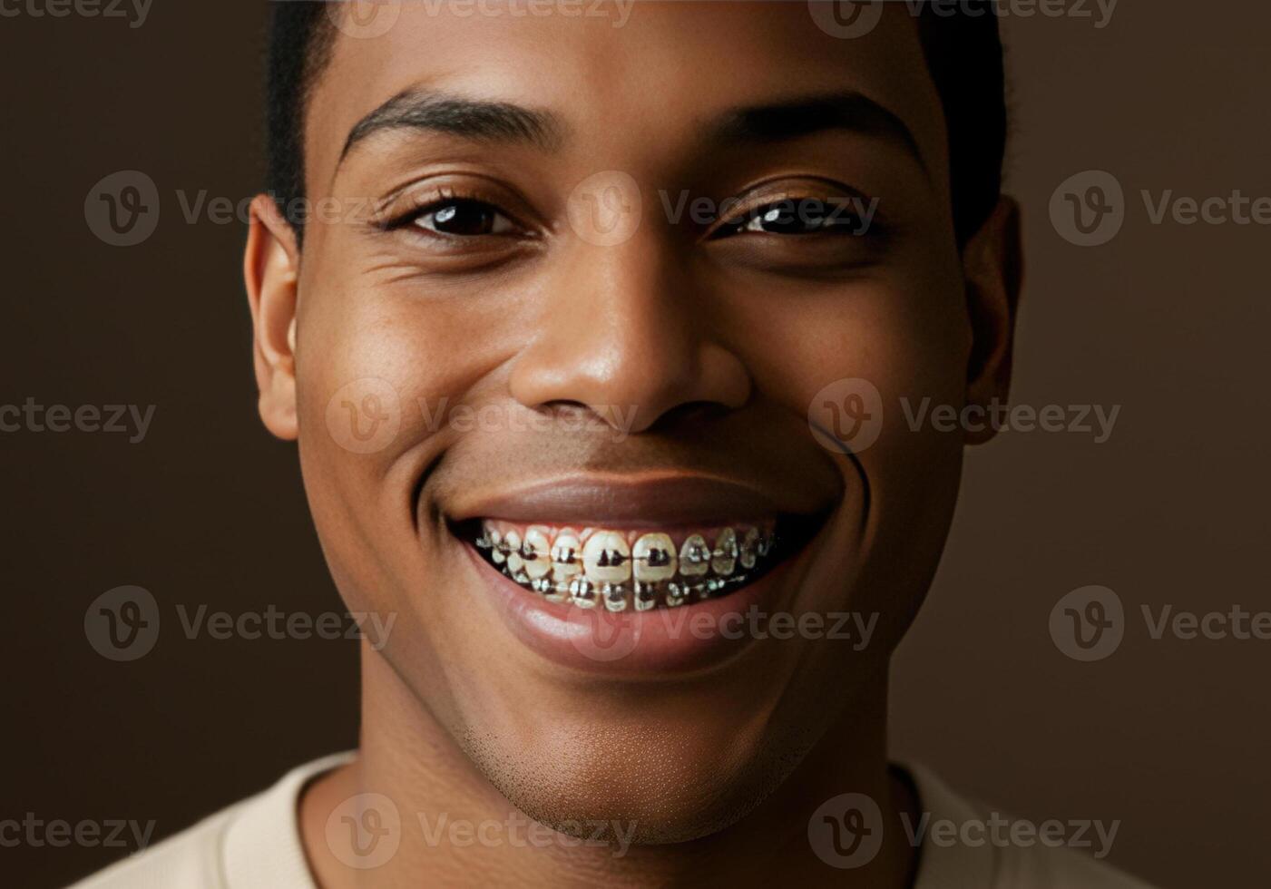 A young African-American man with braces smiles broadly, showcasing his commitment to dental health. photo
