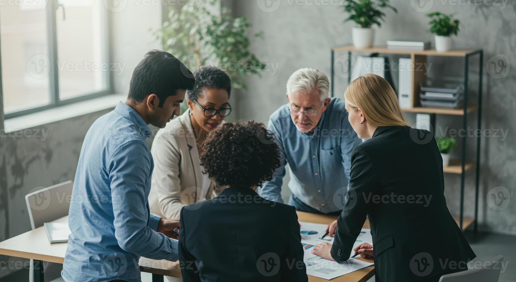 A diverse group of professionals collaborates on a business strategy in a bright, modern office setting. photo