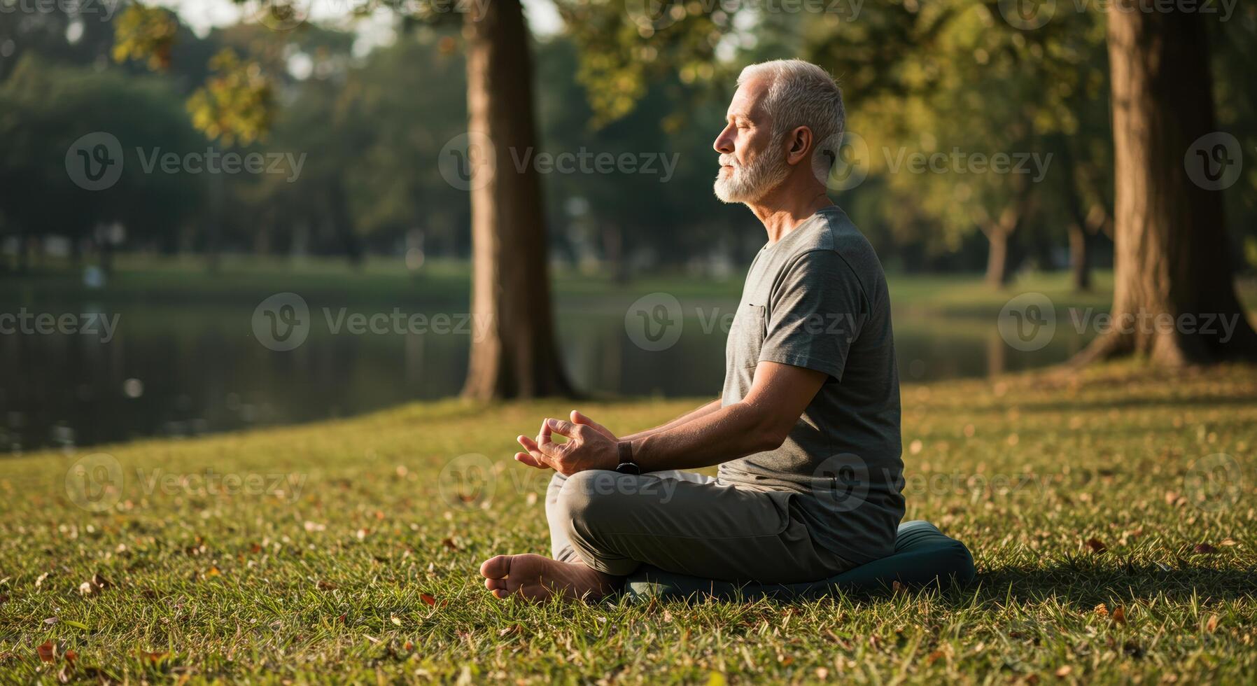 A senior man finds inner peace through mindful meditation in a tranquil park setting by the lake. photo