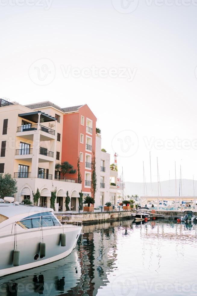 Yachts moored near the pier in front of luxury villas on the shore photo