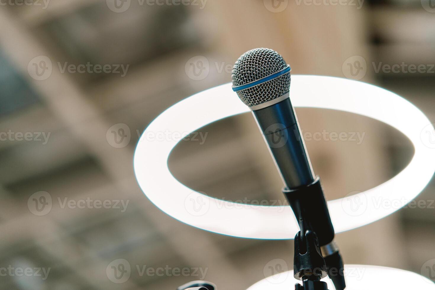 Microphone stands on a stand on the stage against the background of round lamps photo