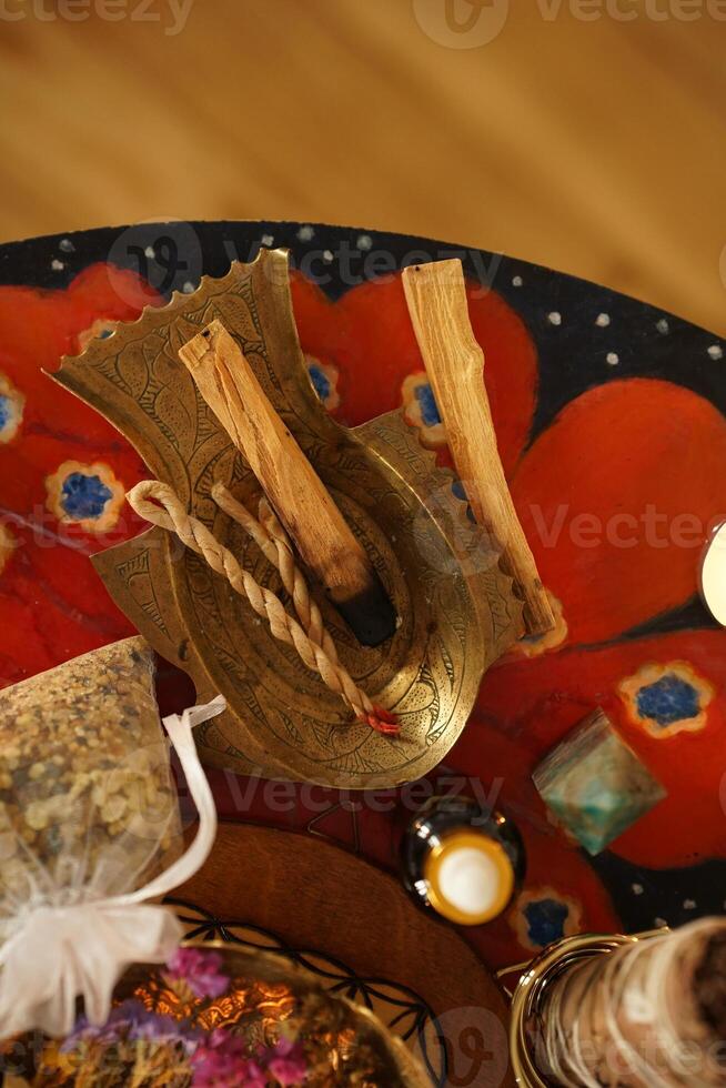 Flat lay view of Palo Santo wood known as oily aromatic holy wood sticks smouldering on plate on home table cleaning negative energy concept. Surrounded with gemstones amethyst and labradorite. photo