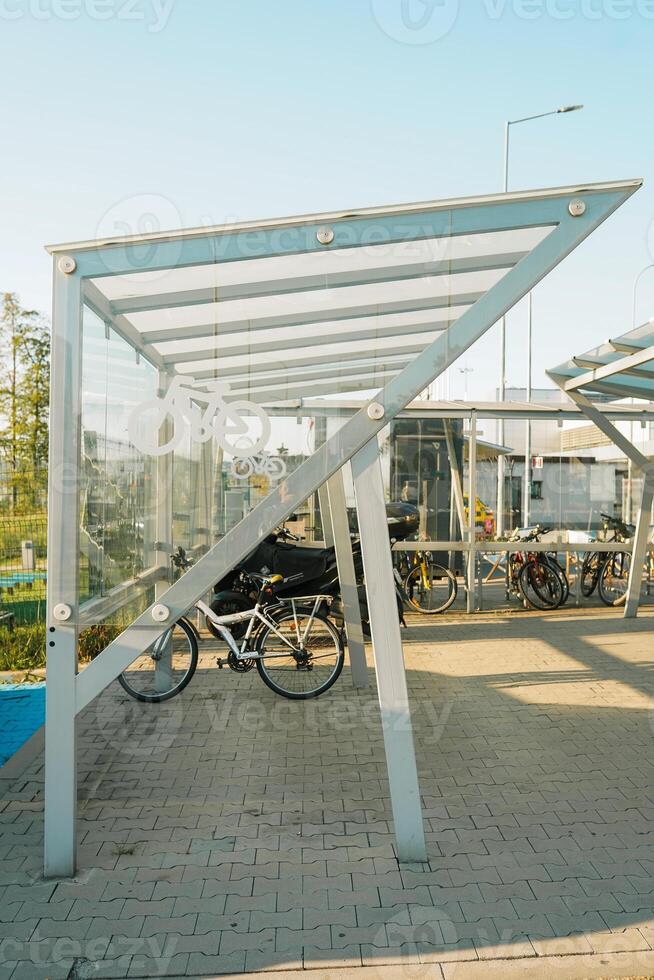parking lot with bicycle stands made of shiny twisted tubes, for inserting and locking the bicycle on the square. interlocking paving and granite cubes in stripes. red, gray, spiral photo