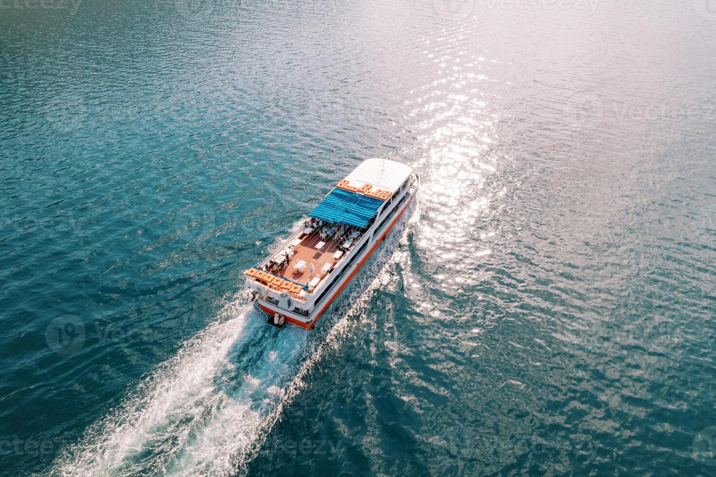 Double-decker excursion ship sails on the blue sea. Top view photo