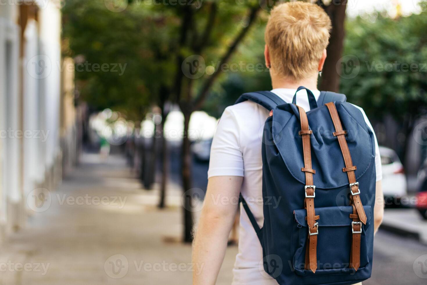 albino young man walking down the street in white clothes photo