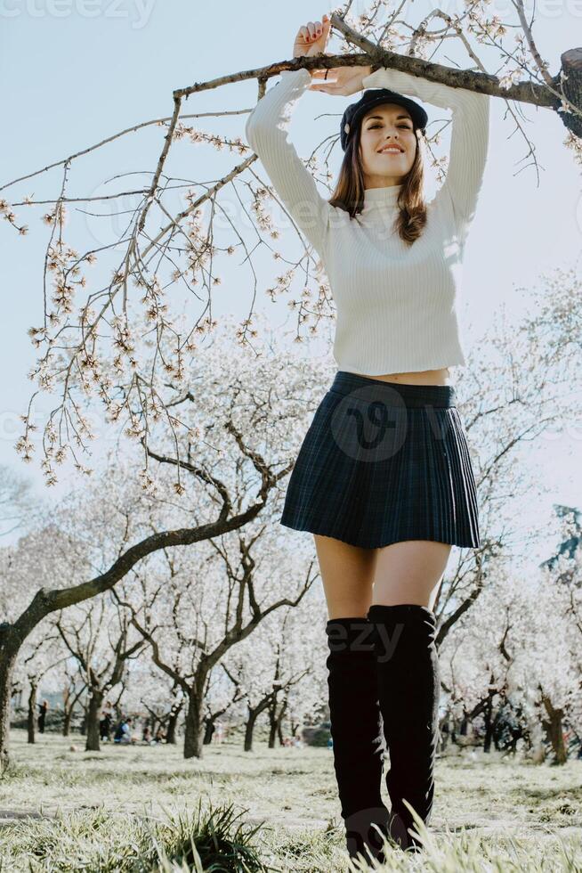 Young happy woman between trees in garden photo