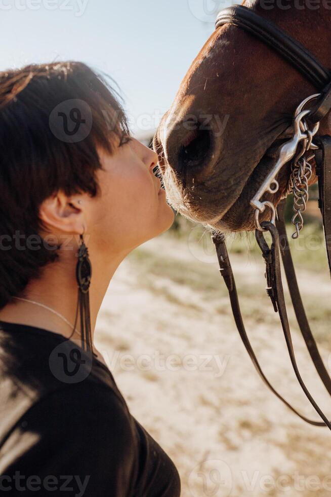 Woman kissing horse on ranch photo