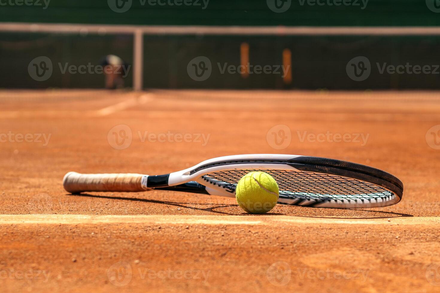Tennis racket and ball on a dirt court photo
