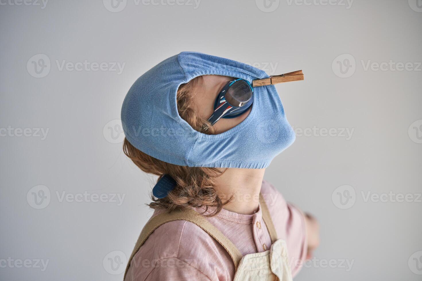Child protecting himself with swimming shorts and goggles against possible infection photo