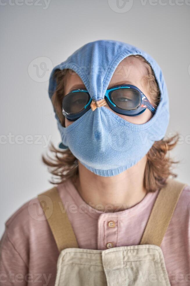 Child protecting himself with swimming shorts and goggles against possible infection photo