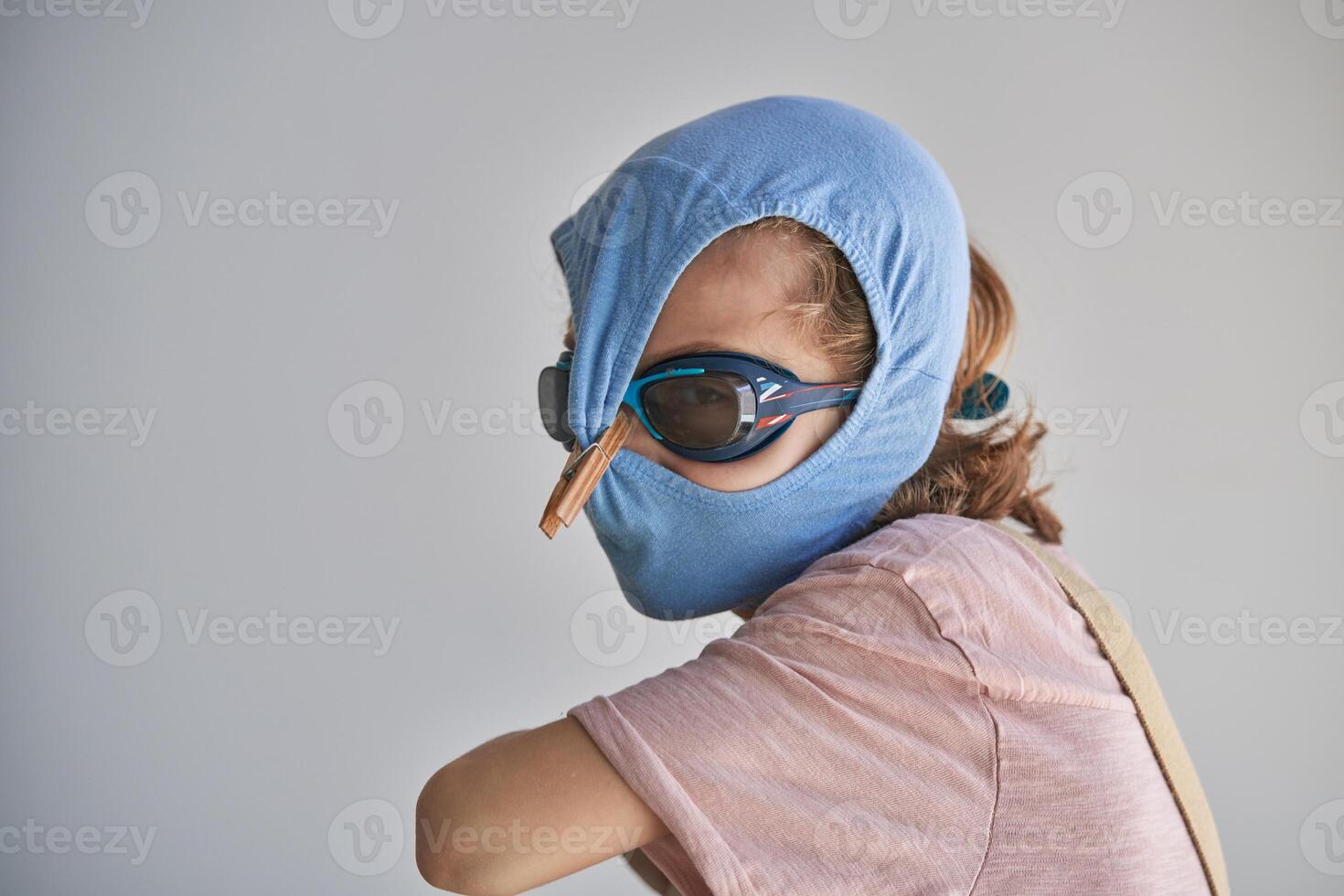 Child protecting himself with swimming shorts and goggles against possible infection photo