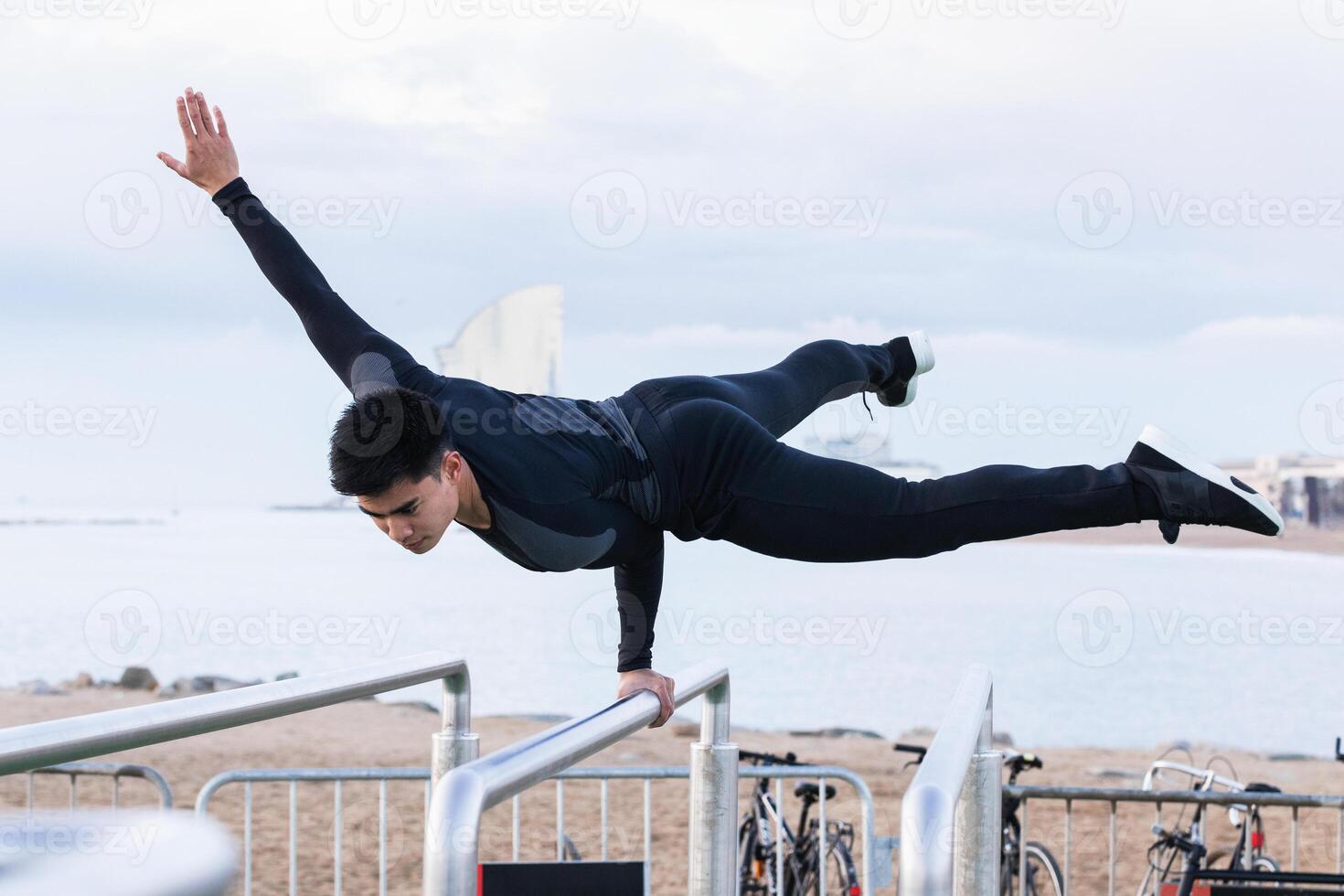 Athlete doing exercise on parallel bars photo