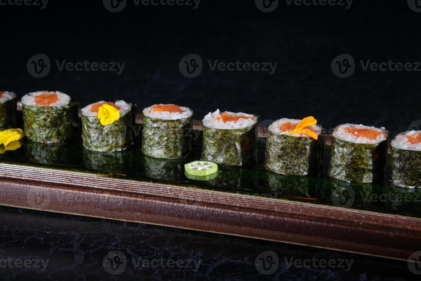 Appetizing sushi rolls with salmon and pepper on tray photo