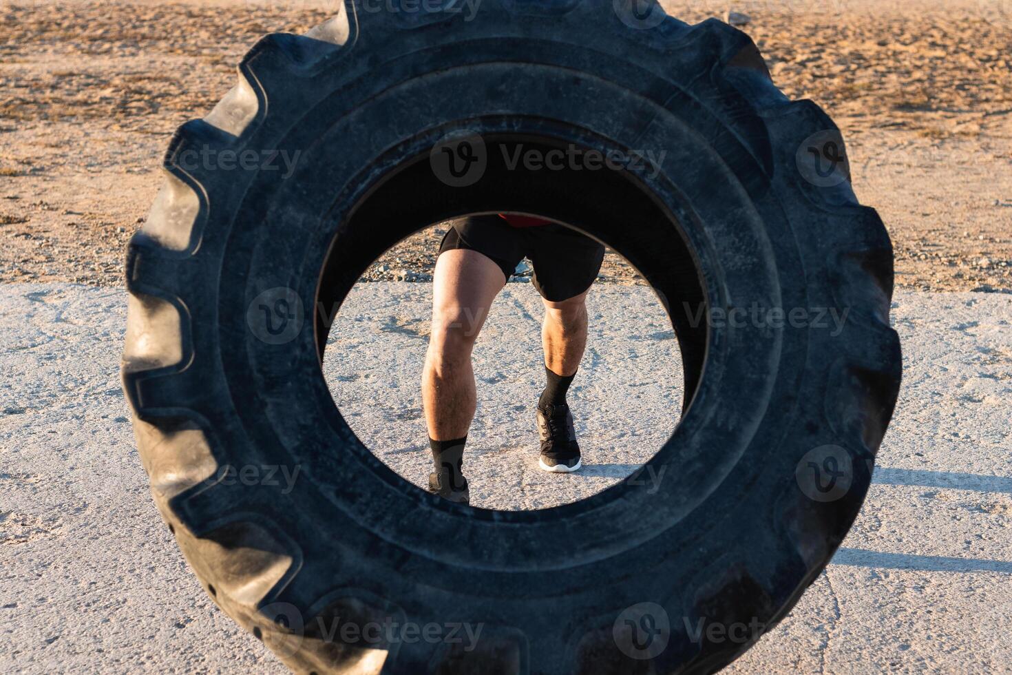 Anonymous strong man doing tire flip exercise photo