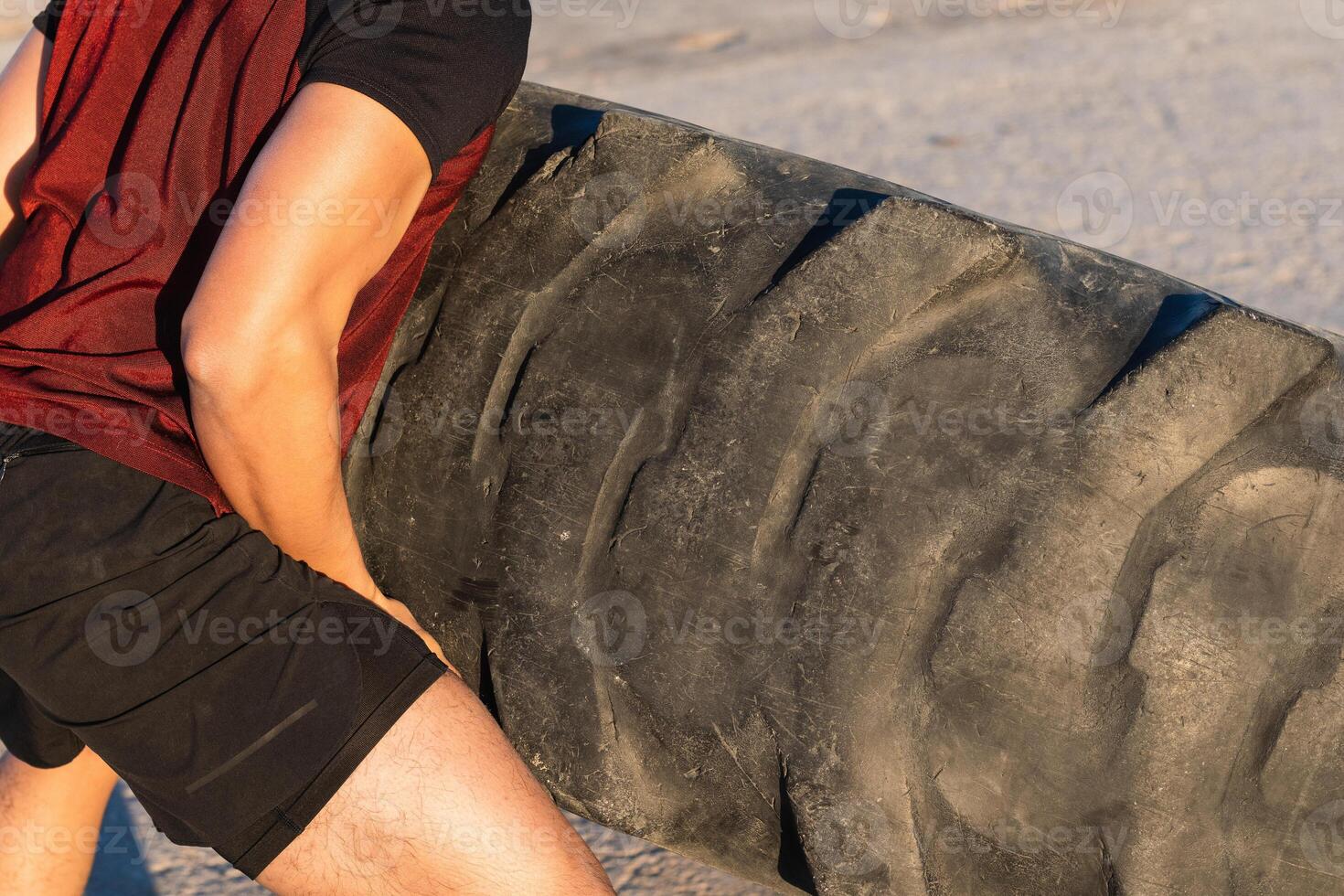 Anonymous strong man doing tire flip exercise photo