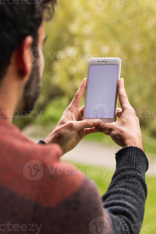 Anonymous man browsing on mobile phone on terrace photo