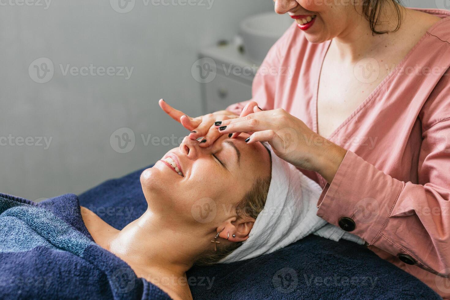 Anonymous masseuse doing massage for woman in spa salon photo