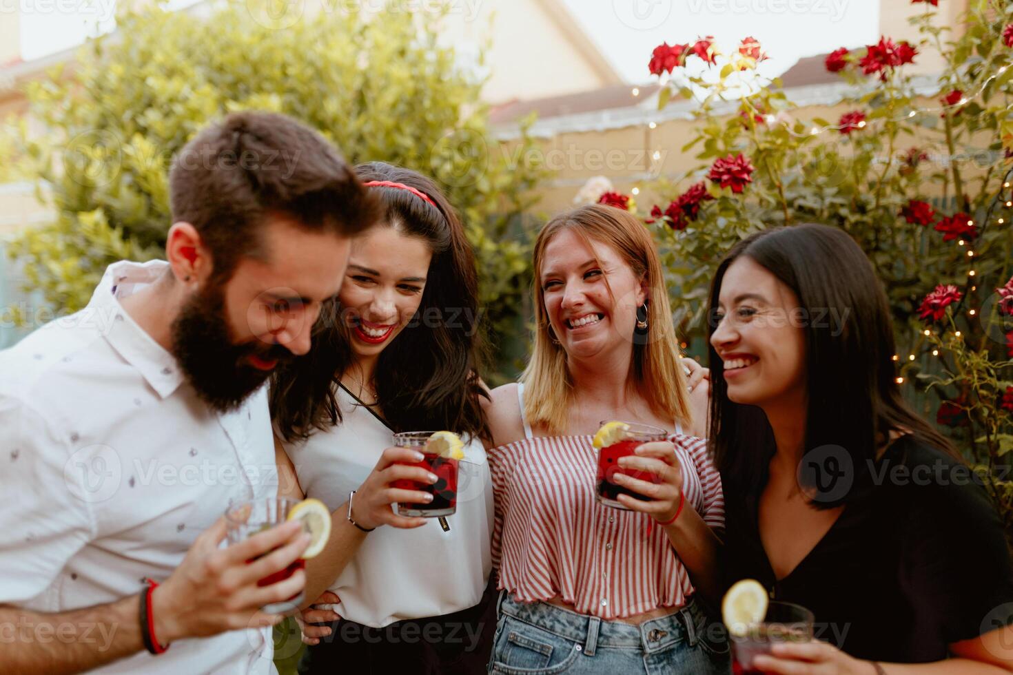 Group of cheerful friends clinking glasses at party photo