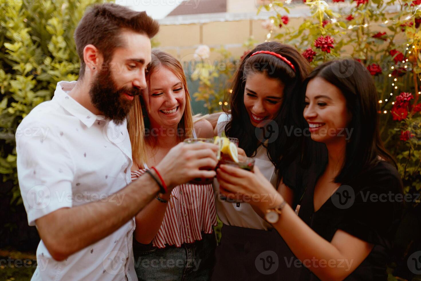 Group of cheerful friends clinking glasses at party photo