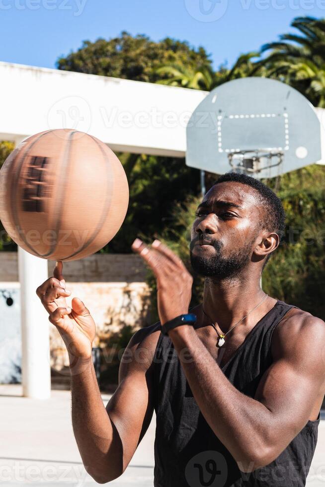 Black man spinning basketball on finger photo