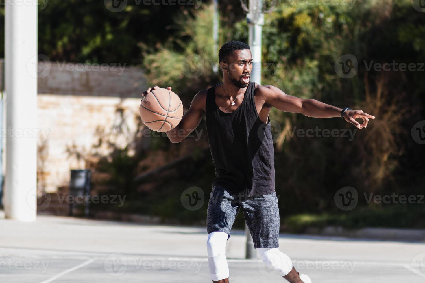 Black man playing basketball on sports ground photo