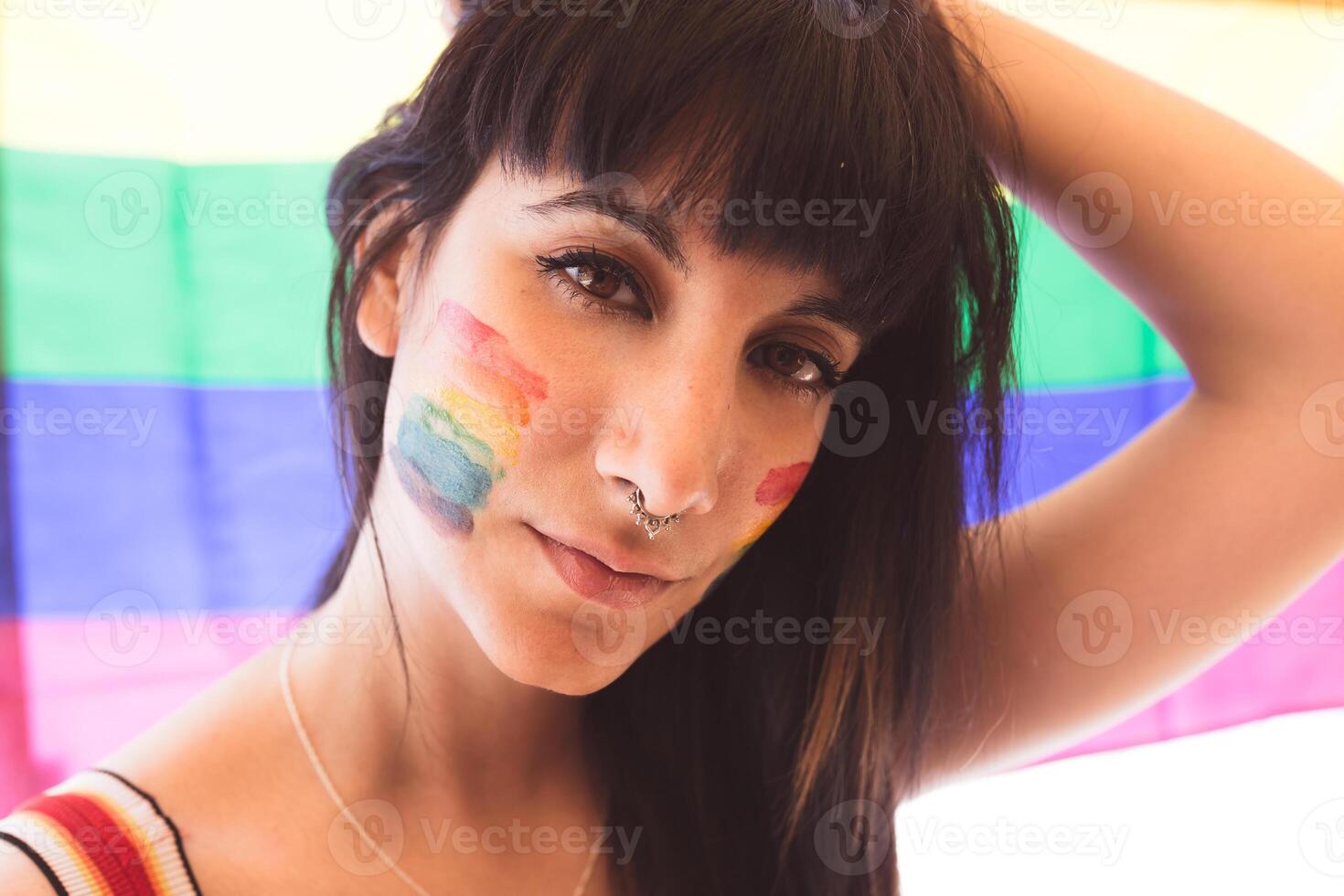 Brunette woman with LGBT symbol on face straightening hair photo