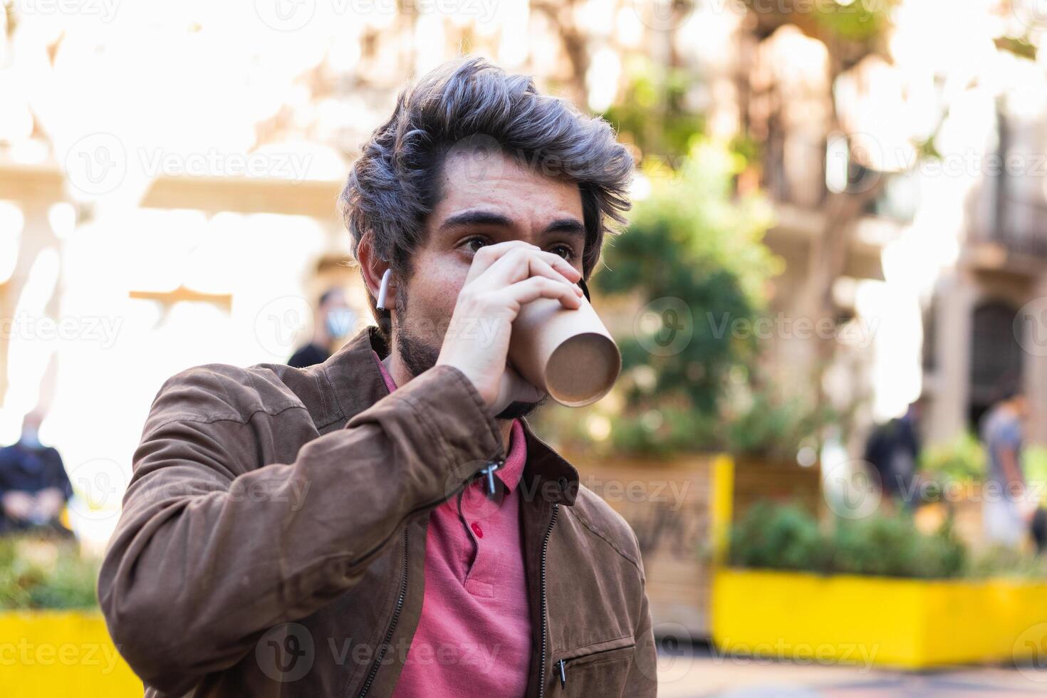 Man drinking coffee to go in city photo