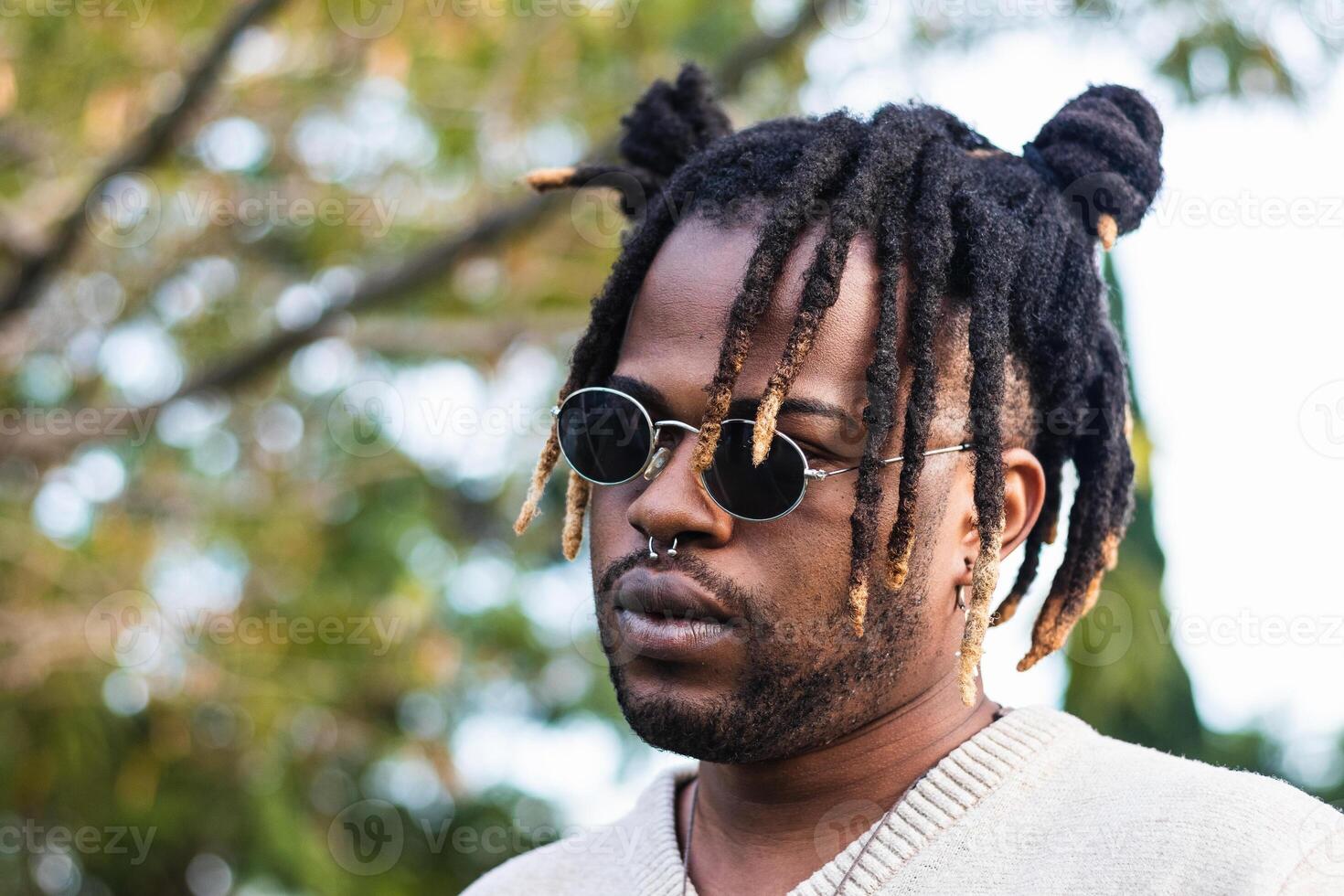 Modern guy with dreadlocks and in accessories photo