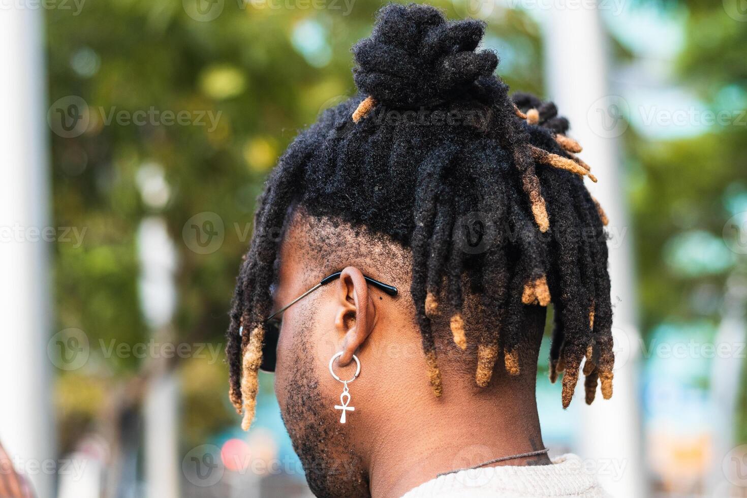 Modern guy with dreadlocks and in accessories photo
