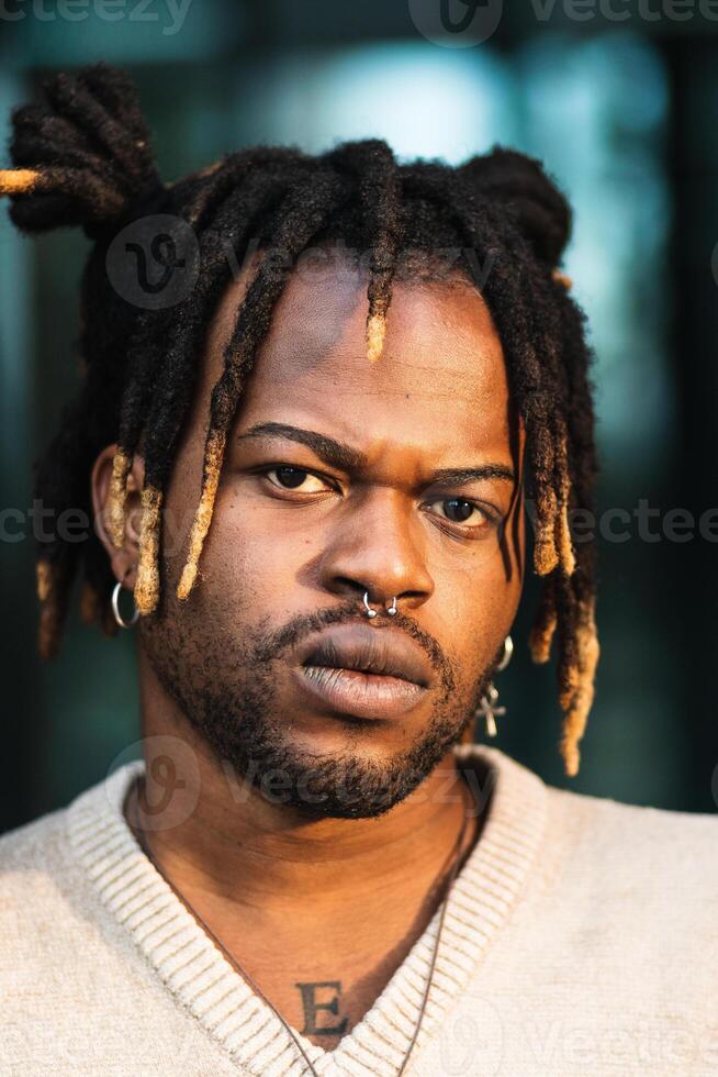 Modern guy with dreadlocks and in accessories photo