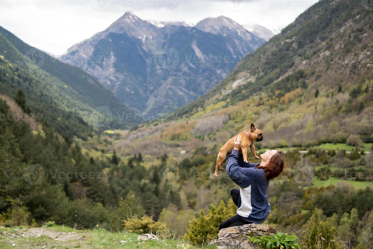 Happy traveling woman with cute dog in highlands photo