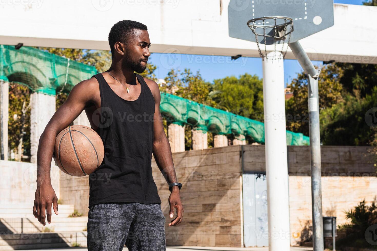 Serious black man with basketball on sports ground photo