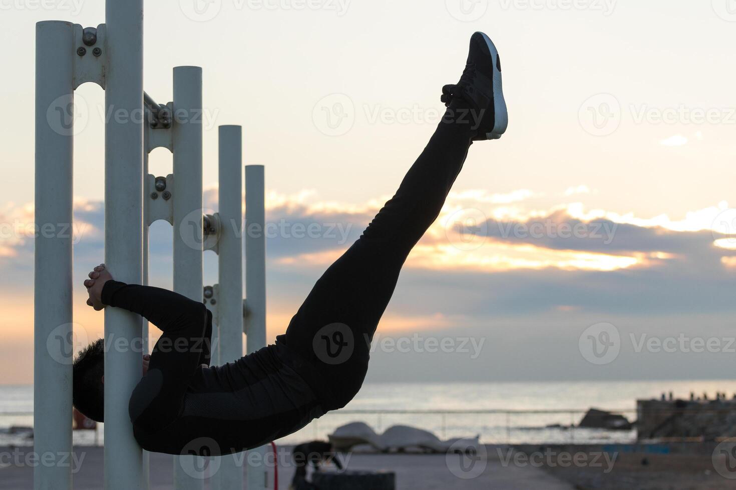Sportsman performing exercise on crossbar photo