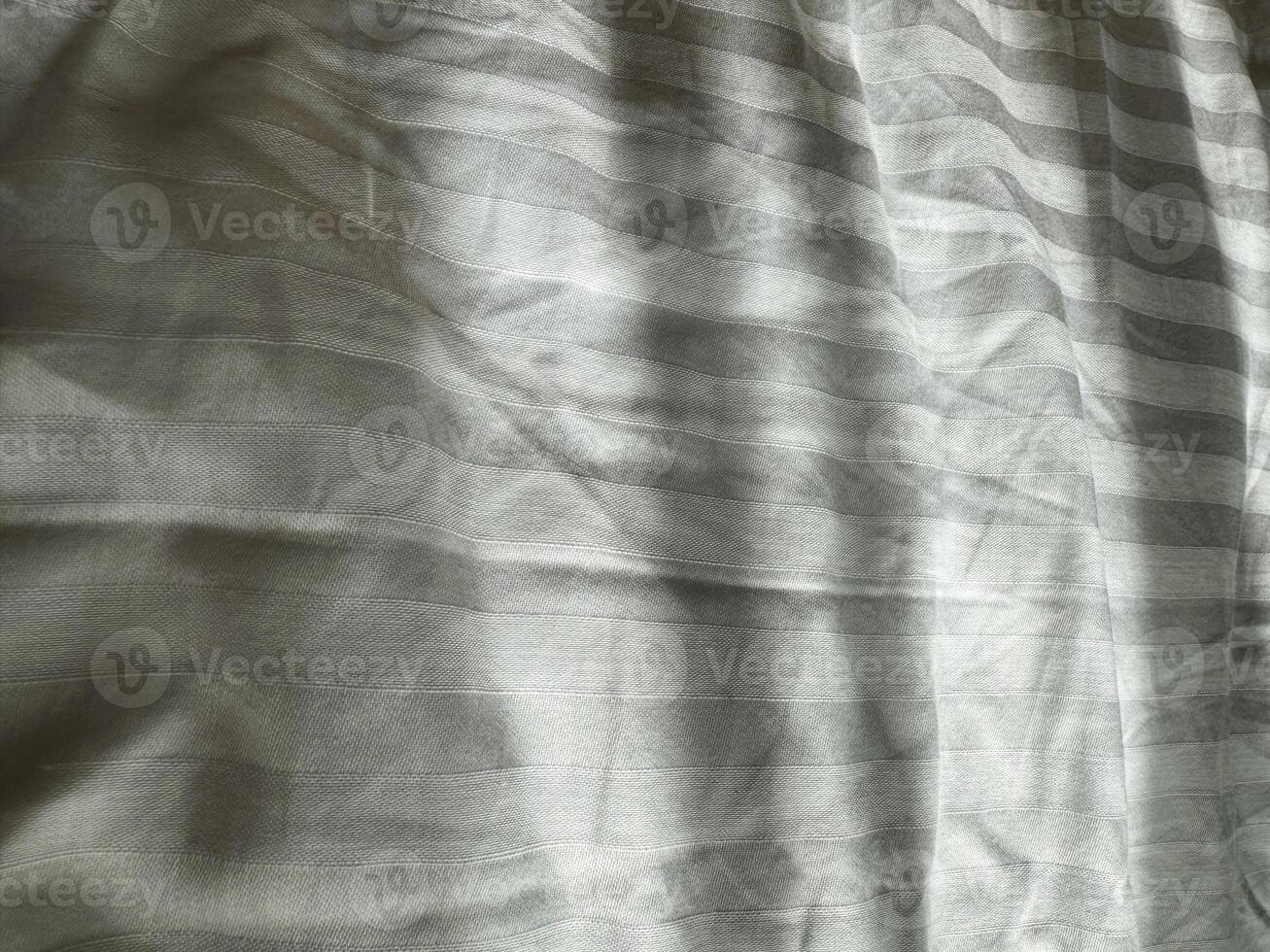 Fabric with subtle texture and light pattern in a neutral shade on a flat surface photo