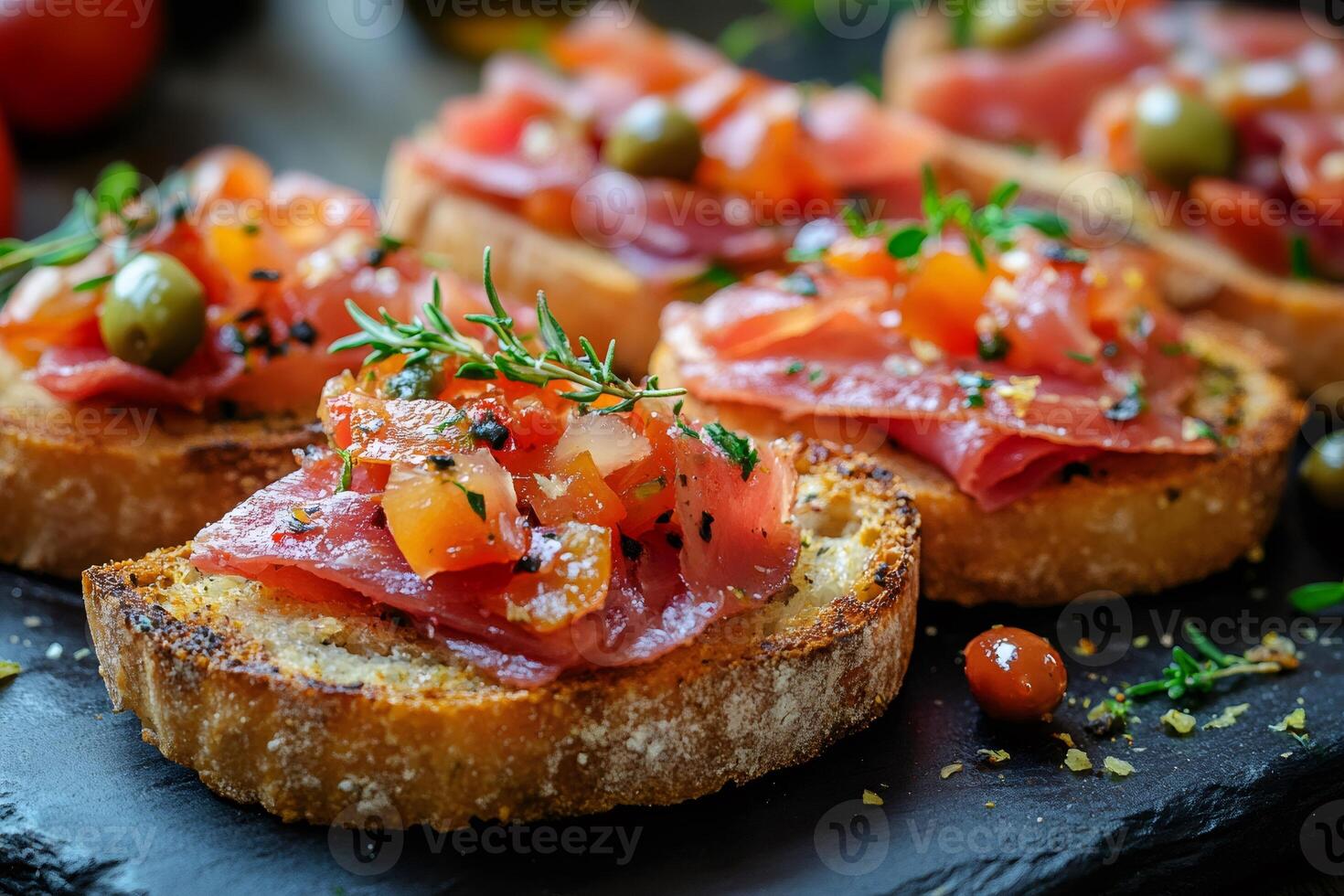 Smoked tuna bruschetta with tomato, capers and herbs being prepared on a slate platter photo