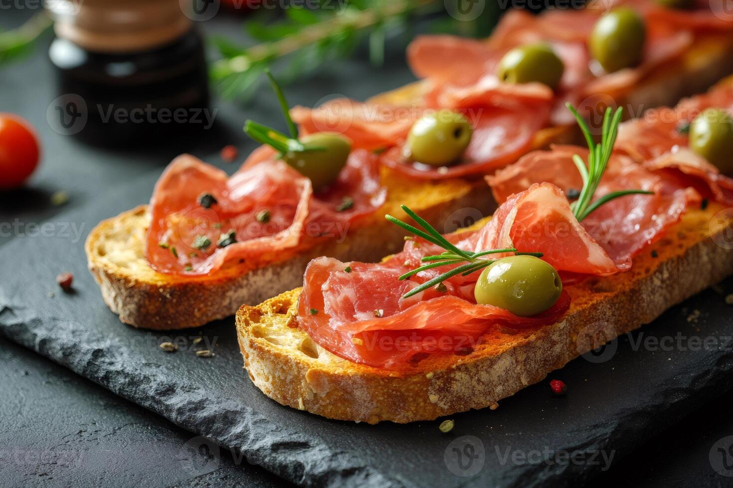 Tasty bruschetta with cured ham, olives and rosemary preparing for a party.. photo