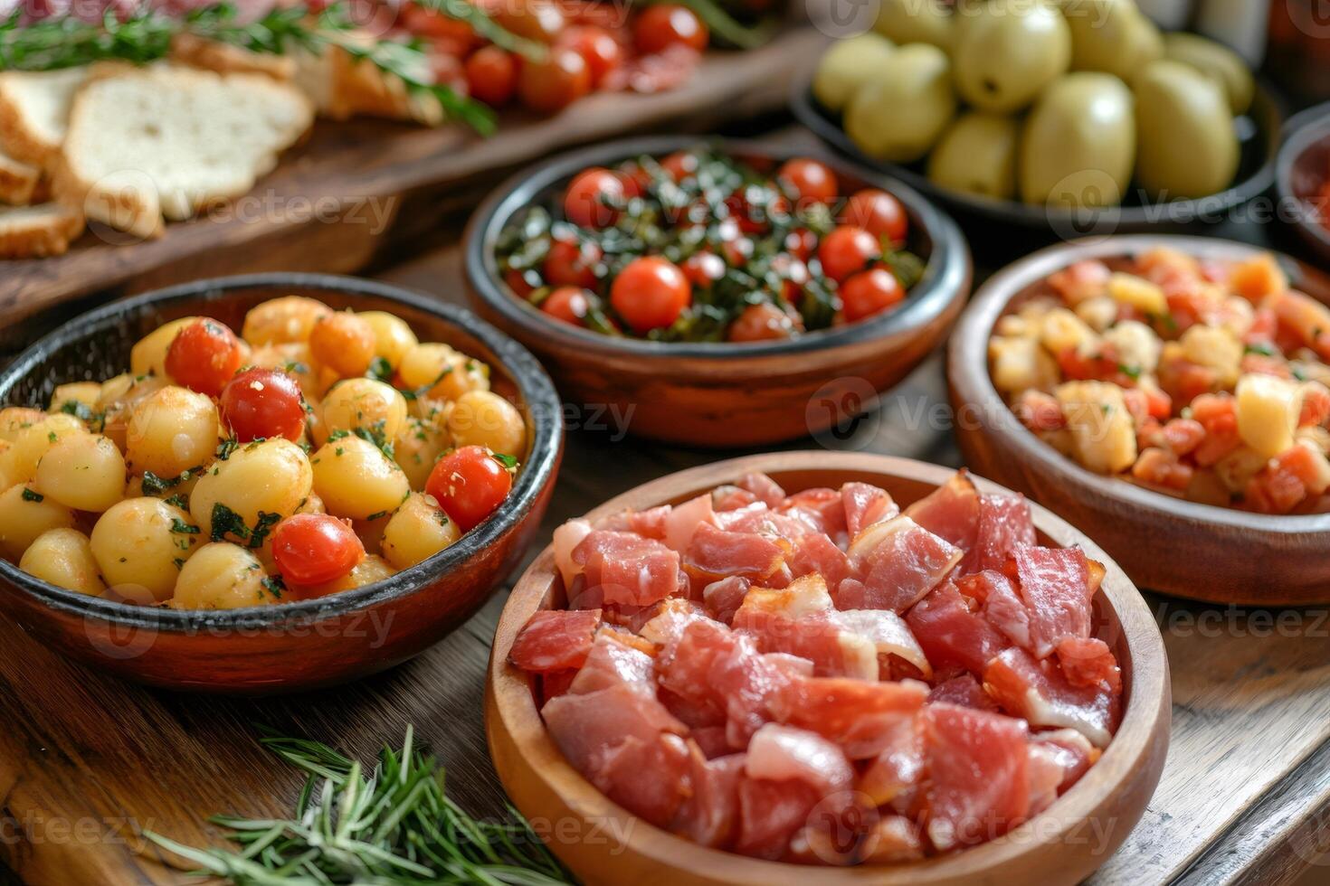 Delicious mediterranean appetizers featuring roasted potatoes, cherry tomatoes, cured ham, and olives photo