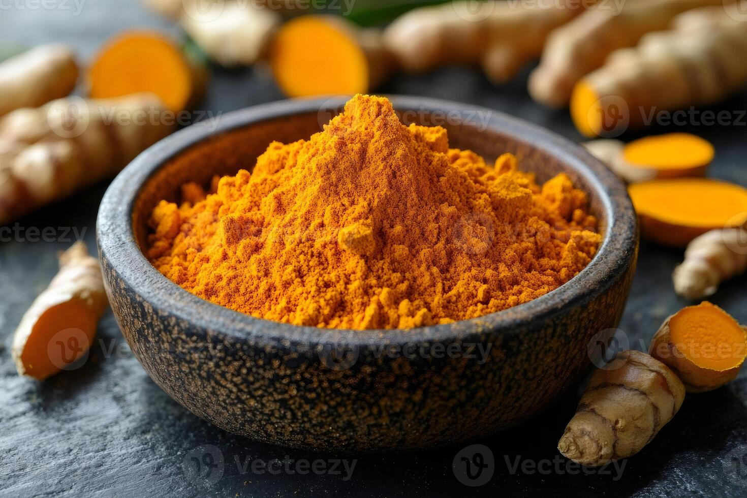 Turmeric powder in wooden bowl with fresh turmeric root ... photo