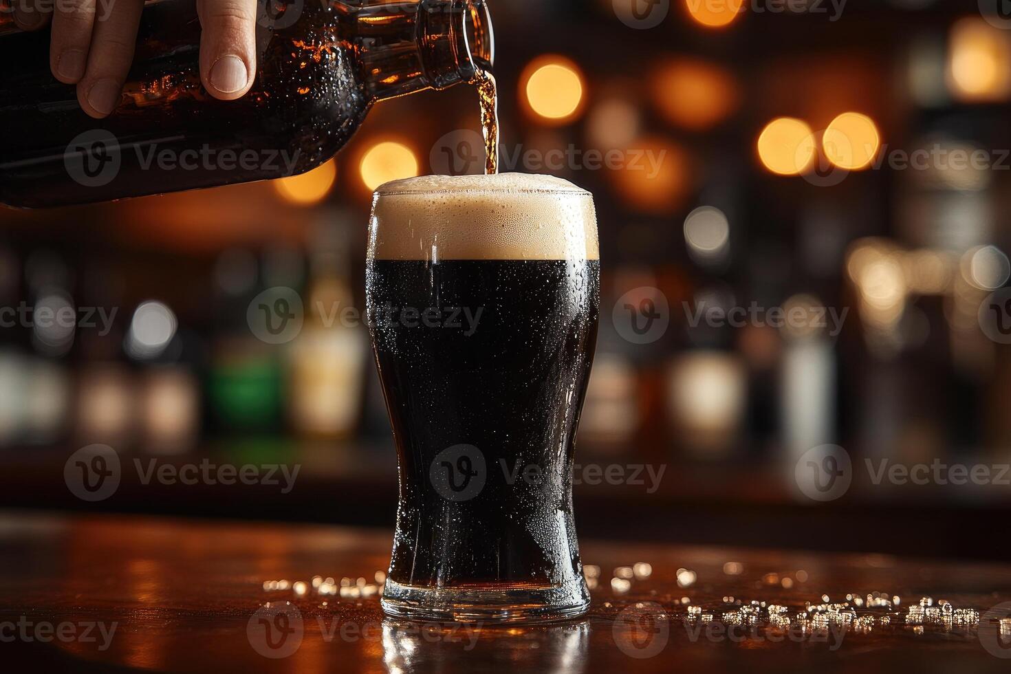 Bartender pouring dark beer into glass.. photo